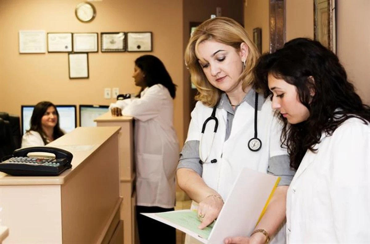 Clinic staff checking a file together at the reception desk